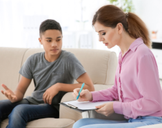 A girl wearing her headset while her mom and the counselor talking